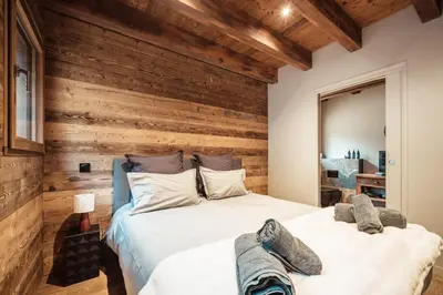 two beds in a bedroom with wooden walls at La Combe Blanche - Balcon sur le Mont-Blanc in Combloux