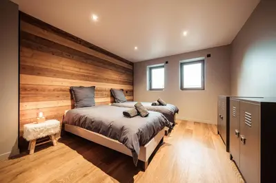 a bedroom with a large bed and two windows at La Combe Blanche - Balcon sur le Mont-Blanc in Combloux