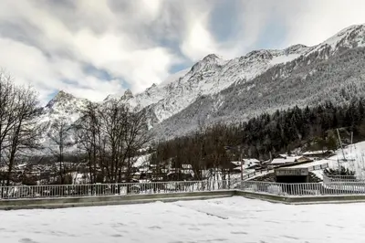 a snow covered mountain with a town in the background at The Bear - Sauna Piscine - Face au Kandahar in Les Houches
