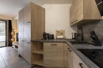 a kitchen with wooden cabinets and a sink at The Bear - Sauna Piscine - Face au Kandahar in Les Houches