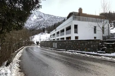 a house on a snow covered street with a building at The Bear - Sauna Piscine - Face au Kandahar in Les Houches