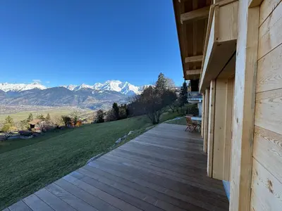 a wooden porch with a view of the mountains at Le Mazot de L'Arpenaz in Combloux