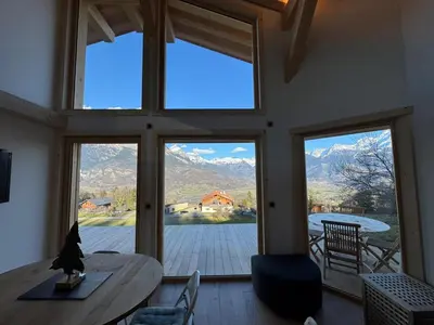 a room with large windows and a table and chairs at Le Mazot de L'Arpenaz in Combloux