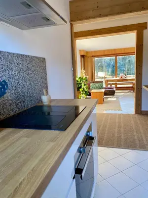 a kitchen with a counter top and a living room at Apartment Chamonix Brise du Mont in Chamonix-Mont-Blanc