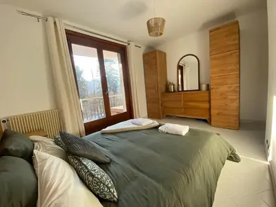 a bedroom with a large bed and a large window at Apartment Chamonix Brise du Mont in Chamonix-Mont-Blanc