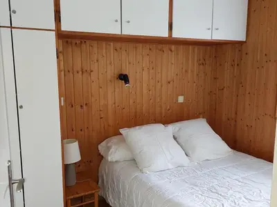 a bedroom with a bed with wooden walls and white pillows at Appartement cosy avec balcon et parking à Chamonix, proche centre-ville - FR-1-517-70 in Chamonix-Mont-Blanc