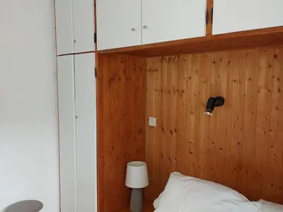 a bedroom with a wooden wall with a bed and a lamp at Appartement cosy avec balcon et parking à Chamonix, proche centre-ville - FR-1-517-70 in Chamonix-Mont-Blanc