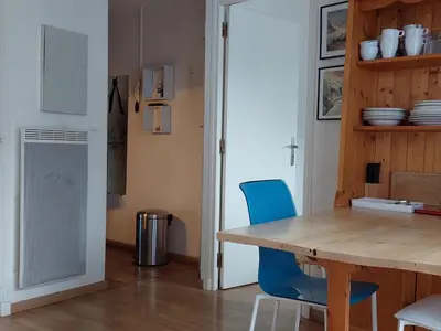 a dining room with a wooden table and blue chairs at Appartement cosy avec balcon et parking à Chamonix, proche centre-ville - FR-1-517-70 in Chamonix-Mont-Blanc