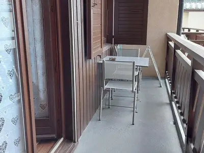 a room with a table and a chair on a porch at Appartement cosy avec balcon et parking à Chamonix, proche centre-ville - FR-1-517-70 in Chamonix-Mont-Blanc