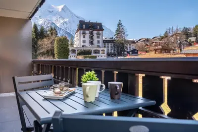 a table on a balcony with a view of a mountain at Appartement des Champs - Welkeys in Chamonix-Mont-Blanc
