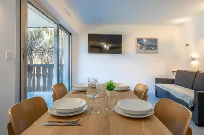 a dining room with a wooden table and chairs at Appartement des Champs - Welkeys in Chamonix-Mont-Blanc