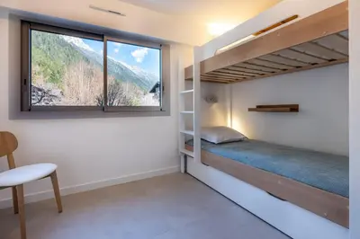 a bedroom with a bunk bed and a window at Appartement des Champs - Welkeys in Chamonix-Mont-Blanc