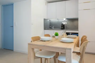 a dining room with a wooden table and chairs at Appartement des Champs - Welkeys in Chamonix-Mont-Blanc