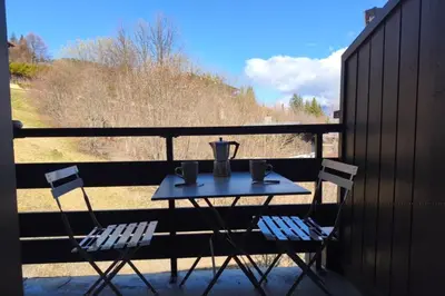 a table with two chairs and a pitcher on a balcony at Cozy Apartment with Balcony Saint-Gervais in Saint-Gervais-les-Bains