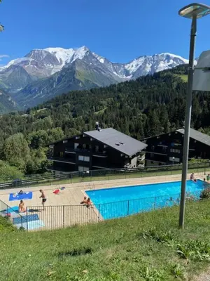 a large swimming pool with mountains in the background at Cozy Apartment with Balcony Saint-Gervais in Saint-Gervais-les-Bains