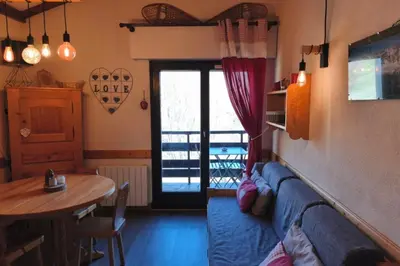 a living room with a blue couch and a table at Cozy Apartment with Balcony Saint-Gervais in Saint-Gervais-les-Bains