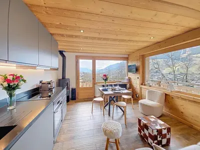 a kitchen and living room with a table and chairs at Chalet Jeane proche du Centre ville de Megève in Megève