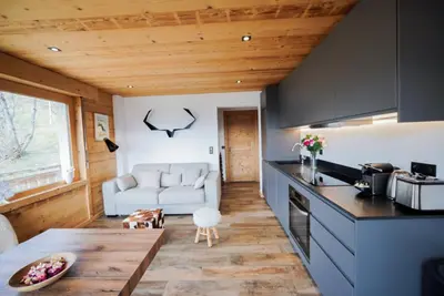 a kitchen with a wooden ceiling and a table with chairs at Chalet Jeane proche du Centre ville de Megève in Megève