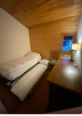 a small room with two beds and a desk at Appartement aux Houches Pied des pistes in Les Houches