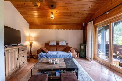 a living room with a bed and a table at Appartement aux Houches Pied des pistes in Les Houches