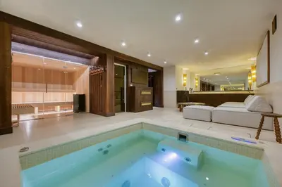 a swimming pool in a room with a living room at Chalet de Luxe 5 chambres Vue MontBlanc ,Spa, Jacuzzi, Salle de sport in Saint-Gervais-les-Bains
