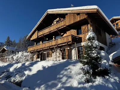a log cabin in the snow with a christmas tree at Chalet de Luxe 5 chambres Vue MontBlanc ,Spa, Jacuzzi, Salle de sport in Saint-Gervais-les-Bains