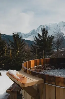 a hot tub with a view of a snowy mountain at Chalet de Luxe 5 chambres Vue MontBlanc ,Spa, Jacuzzi, Salle de sport in Saint-Gervais-les-Bains