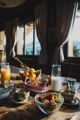 a wooden table topped with bowls of fruit and milk at Chalet de Luxe 5 chambres Vue MontBlanc ,Spa, Jacuzzi, Salle de sport in Saint-Gervais-les-Bains