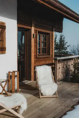 a white chair on a porch of a cabin at Chalet de Luxe 5 chambres Vue MontBlanc ,Spa, Jacuzzi, Salle de sport in Saint-Gervais-les-Bains