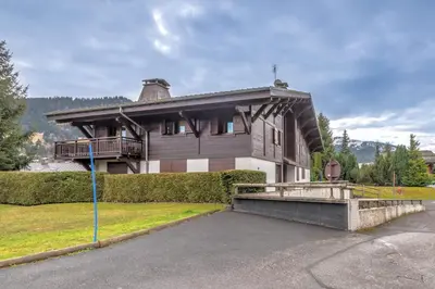 a large house with a porch and a driveway at Appartement Piton - Welkeys in Megève
