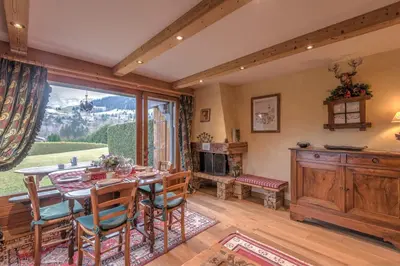 a dining room with a table and a large window at Appartement Piton - Welkeys in Megève