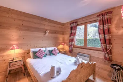 a bedroom with a bed in a log cabin at Appartement Piton - Welkeys in Megève