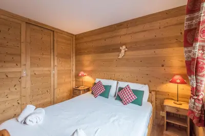 a bedroom with a bed in a wooden room at Appartement Piton - Welkeys in Megève