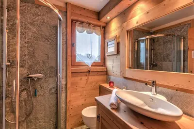 a bathroom with a sink and a shower and a toilet at Appartement Piton - Welkeys in Megève