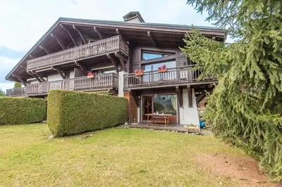 a large wooden house with a large balcony at Appartement Piton - Welkeys in Megève