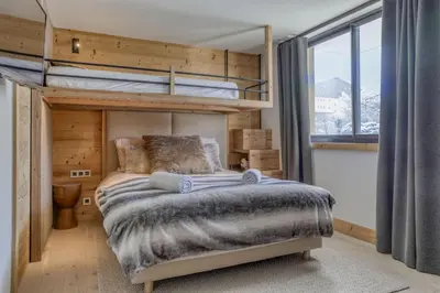 a bedroom with a bunk bed and a large window at Megeve les skis aux pieds in Megève