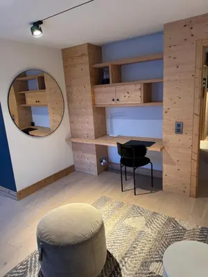 a room with a table and a chair and a mirror at Megeve les skis aux pieds in Megève