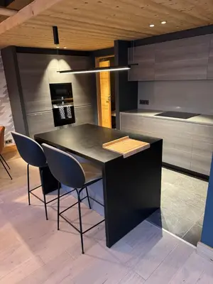 a kitchen with a black table and chairs in it at Megeve les skis aux pieds in Megève
