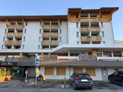 a building with cars parked in front of it at Megeve les skis aux pieds in Megève