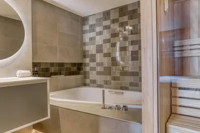 a bathroom with a bath tub and a sink at Megeve les skis aux pieds in Megève