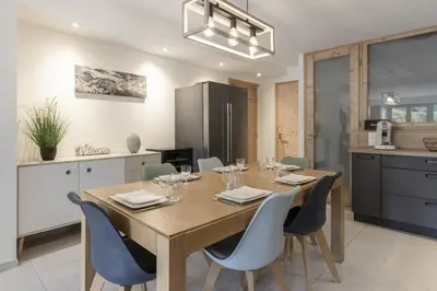 a kitchen and dining room with a wooden table and chairs at Pierre Belle - 80m2 - Grande Terrasse et Jardin in Chamonix-Mont-Blanc