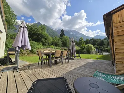 a wooden deck with a table and chairs and umbrellas at Pierre Belle - 80m2 - Grande Terrasse et Jardin in Chamonix-Mont-Blanc