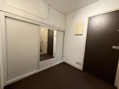 an empty room with a door and a mirror at 2P Chamonix Aiguille du Midi in Chamonix-Mont-Blanc