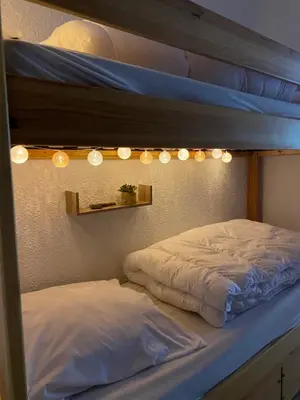 two beds in a room with lights above them at Studio Cosy 4 personnes avec jardin in Combloux