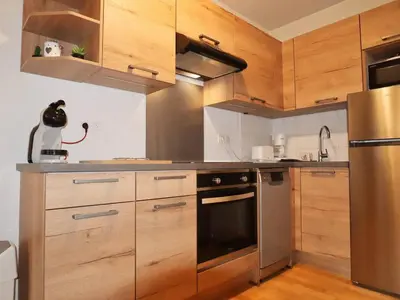 a kitchen with wooden cabinets and a stainless steel refrigerator at Appartement T2 6 pers avec Wifi et parking couvert - FR-1-629-145 in Samoëns