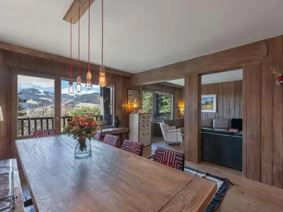 a dining room and living room with a large wooden table at Fairway in Megève