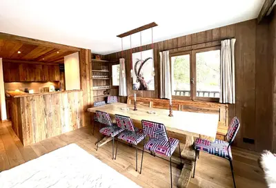 a kitchen with a counter with chairs and a sink at Fairway in Megève
