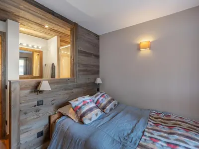a bedroom with a bed with a wooden wall at Fairway in Megève