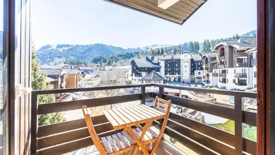 a wooden bench on a balcony with a view of a city at Grand Horizon 1 N401 - 3P6 in Morillon