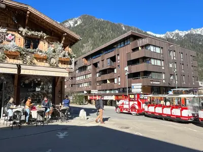 a red train on a street next to a building at Mont Blanc Panorama in Chamonix-Mont-Blanc